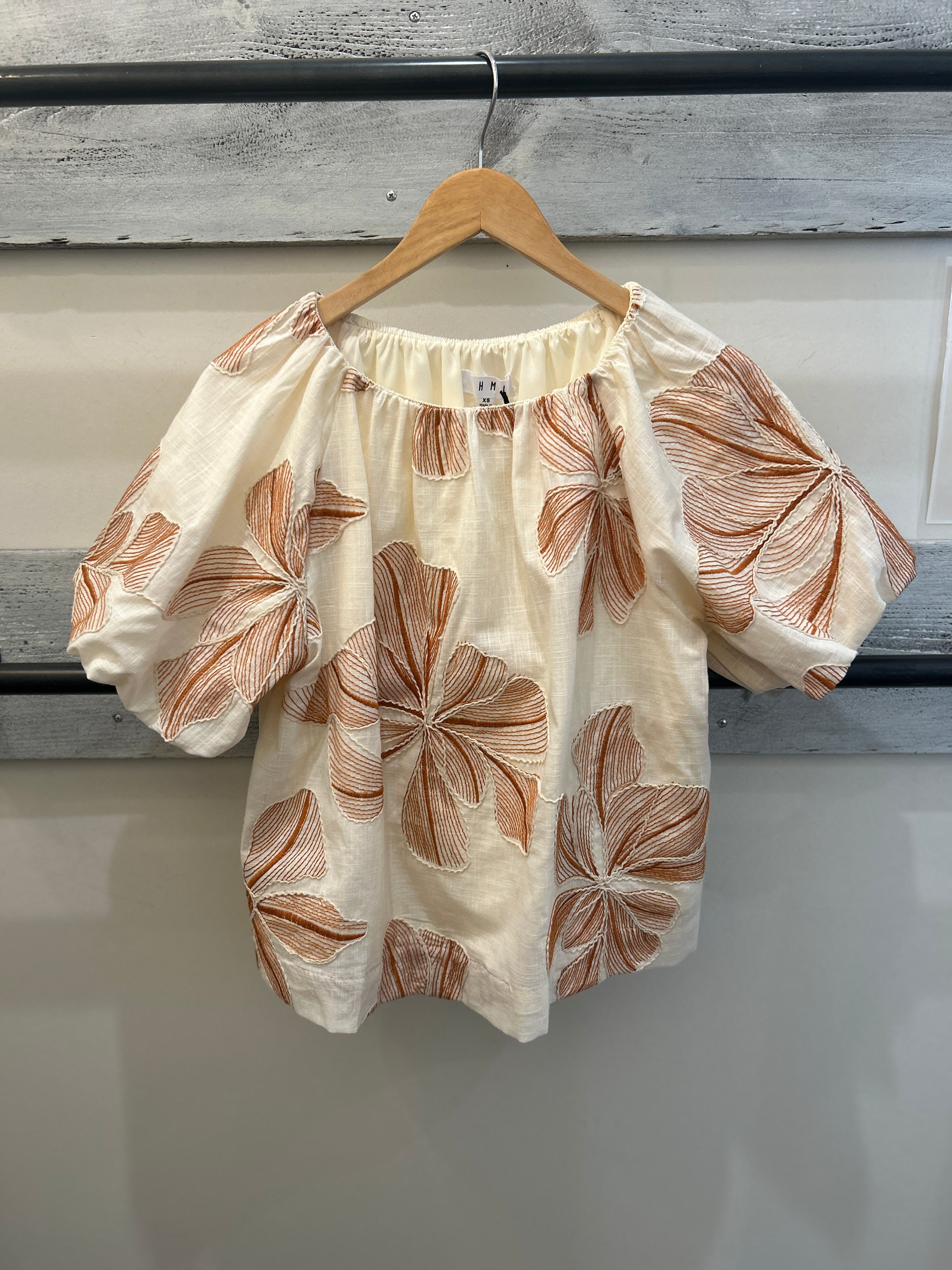 beige top with brown floral pattern