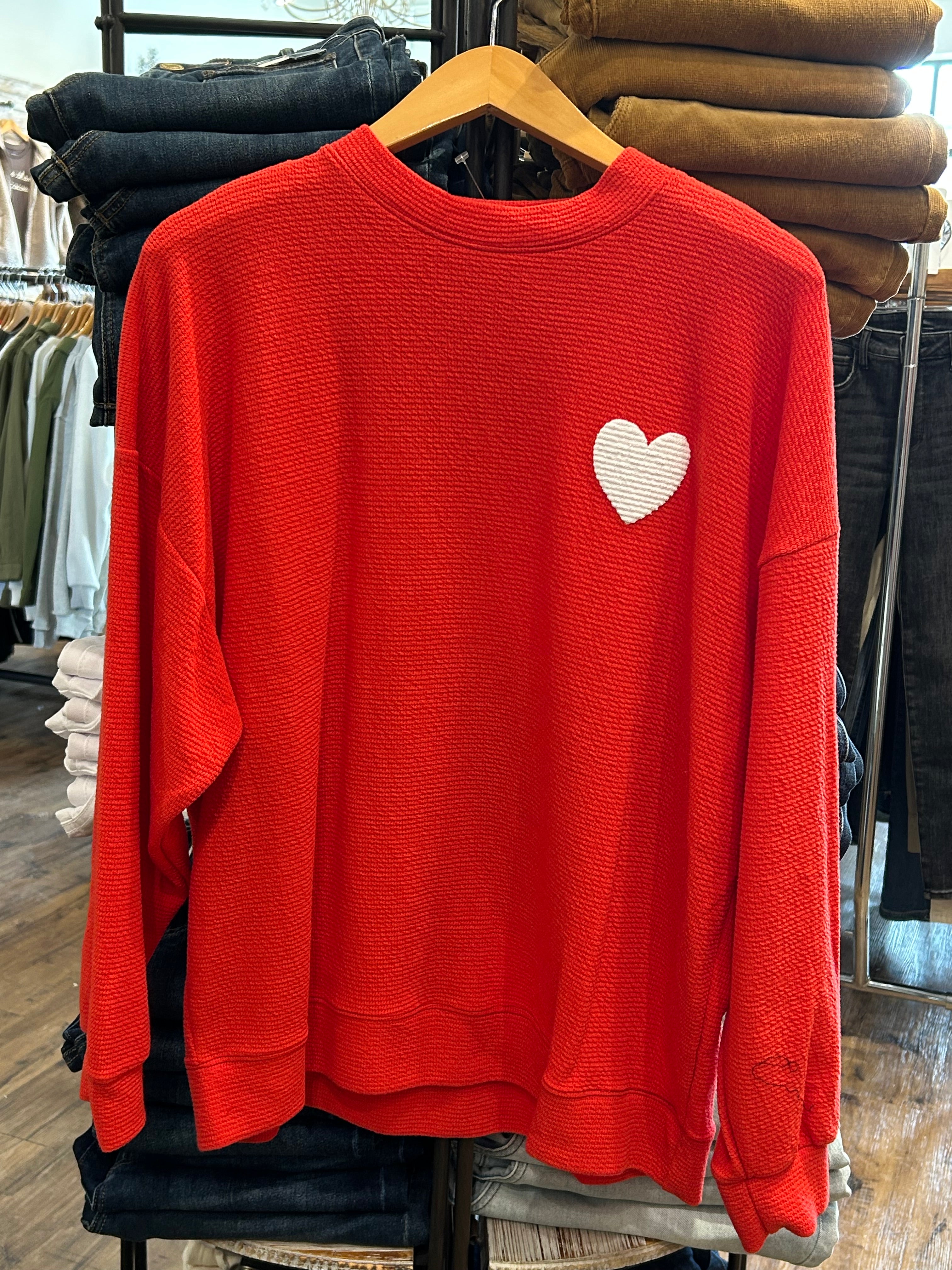 Red sweatshirt with a white heart design.