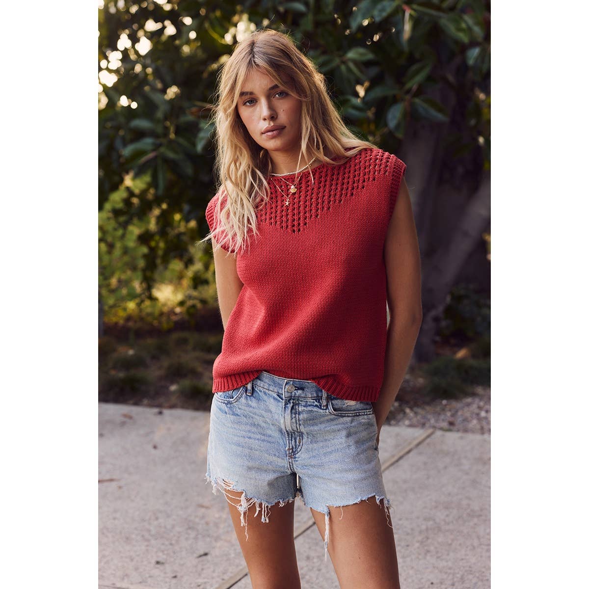 red sleeveless open knit sweater with front yoke detail