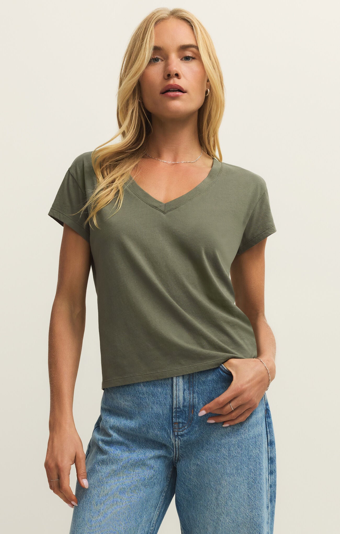 Woman wearing an olive green V-neck t-shirt