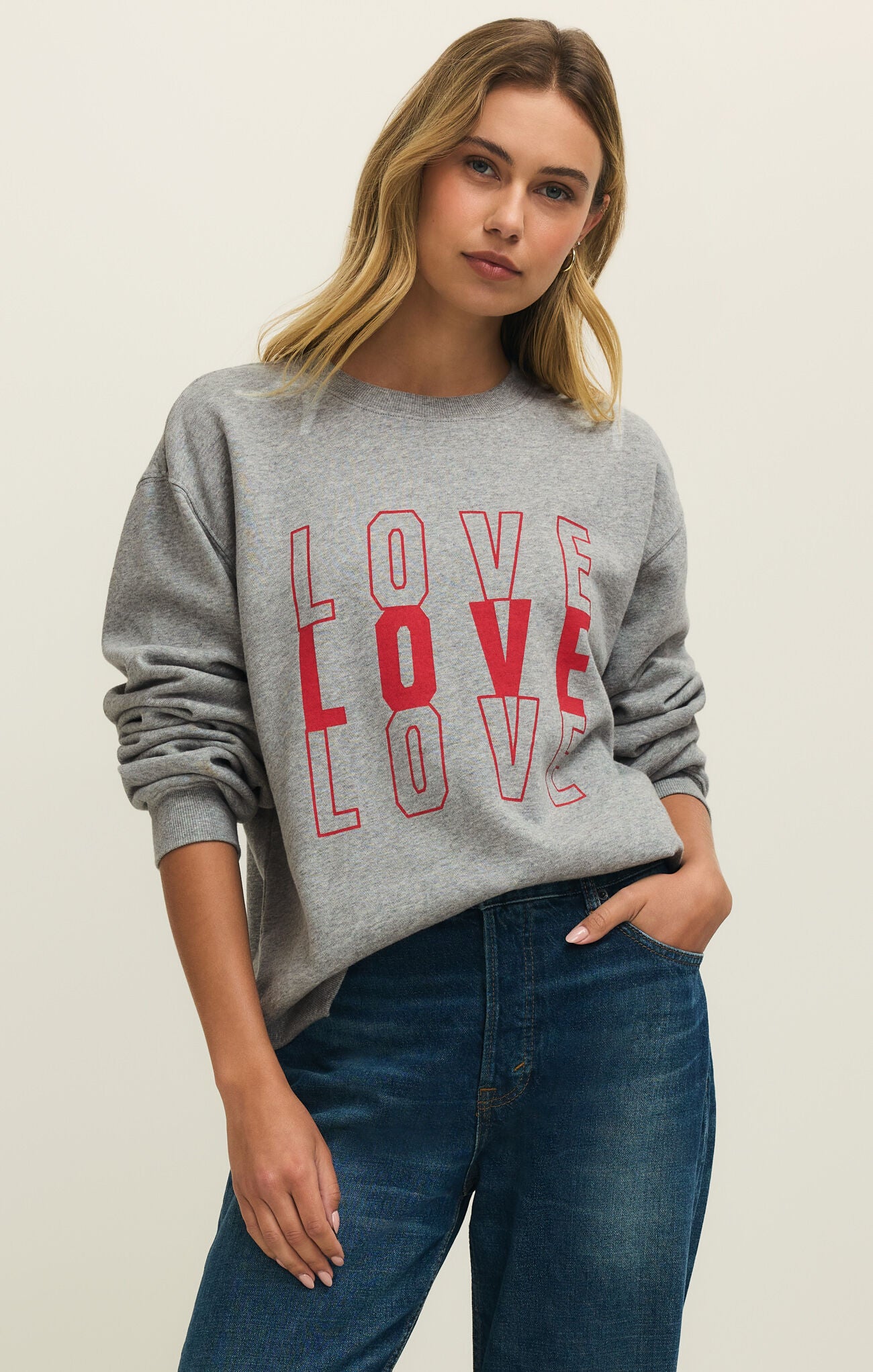 Woman wearing a gray sweatshirt with 'LOVE' printed in red.