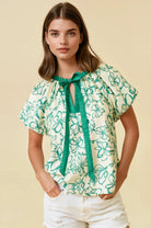 white and green floral short sleeve blouse with tie collar