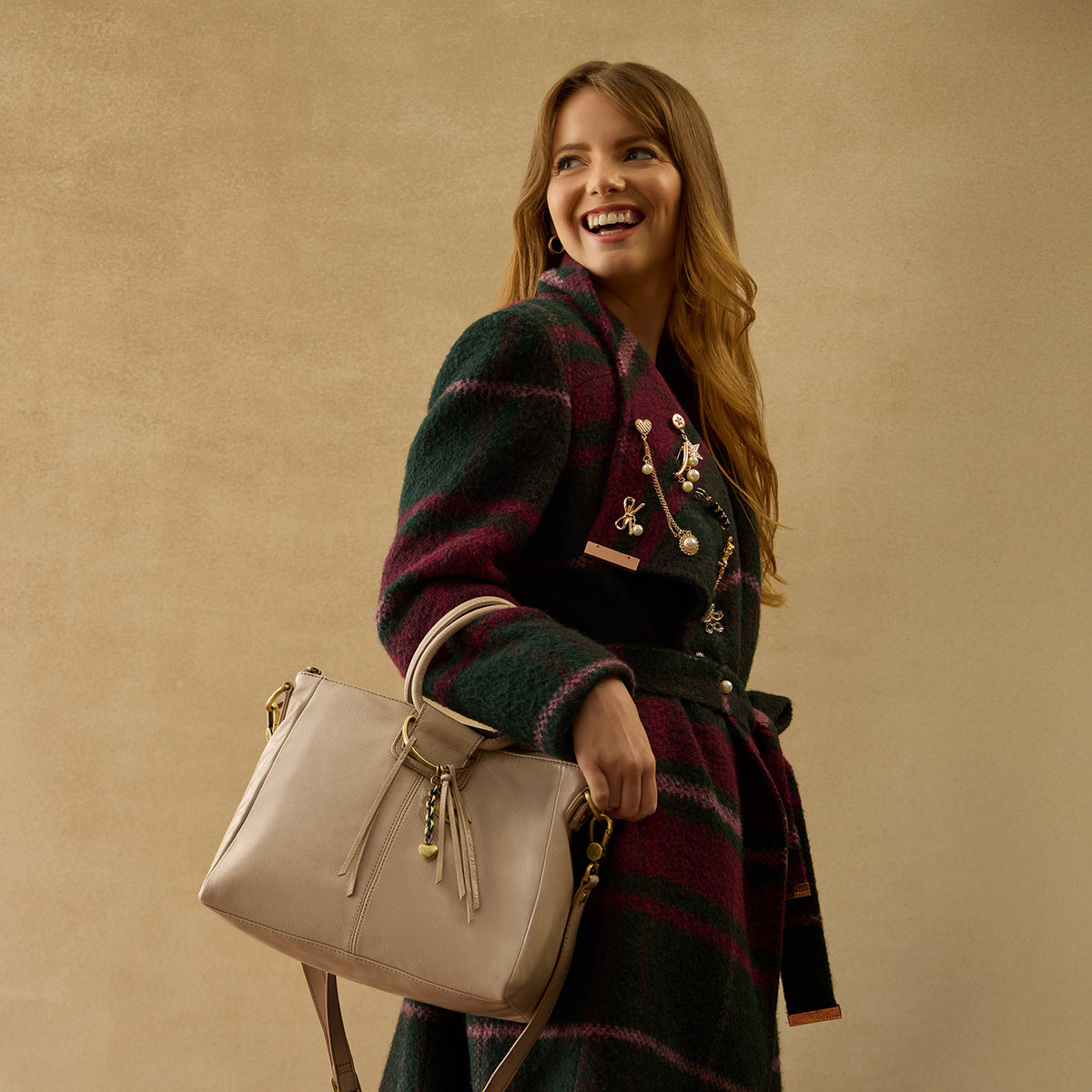 HOBO medium beige satchel bag with gold accents.