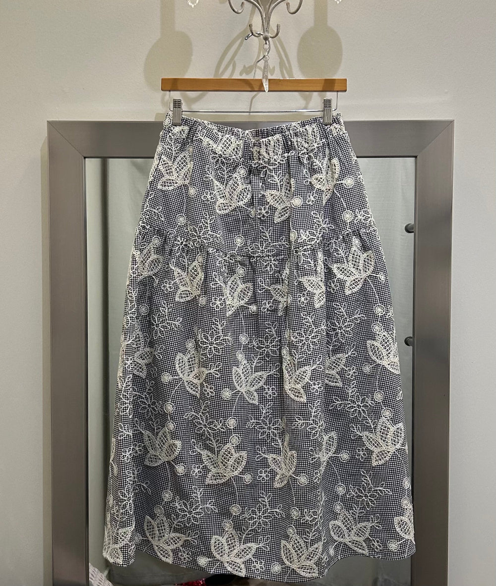 Tiered skirt with floral embroidery over black gingham fabric