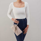 HOBO beige wristlet with circular handle and gold charms