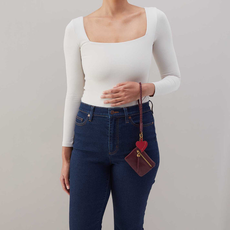 This wristlet features our signature Lasso heart charm, and tethers your phone to the bag. 