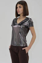 Woman wearing a metallic black short sleeve v neck top