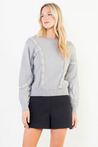 Grey long sleeve sweater with raised white and grey accent